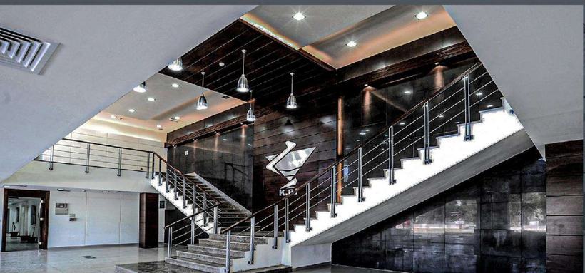 Al Kindi Pharmaceutical entrance hall with split staircase and bronze panels, Amman