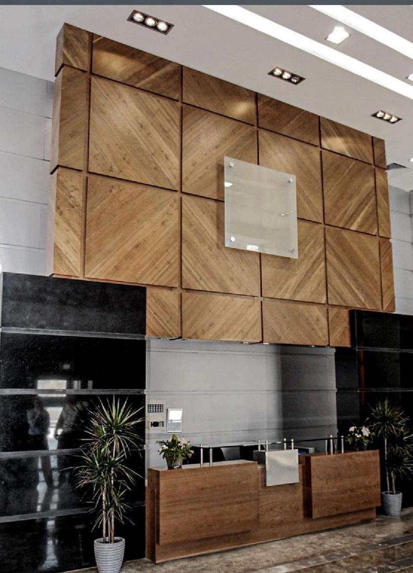 Rabia Towers lobby with chevron walnut feature wall and concierge desk, Amman
